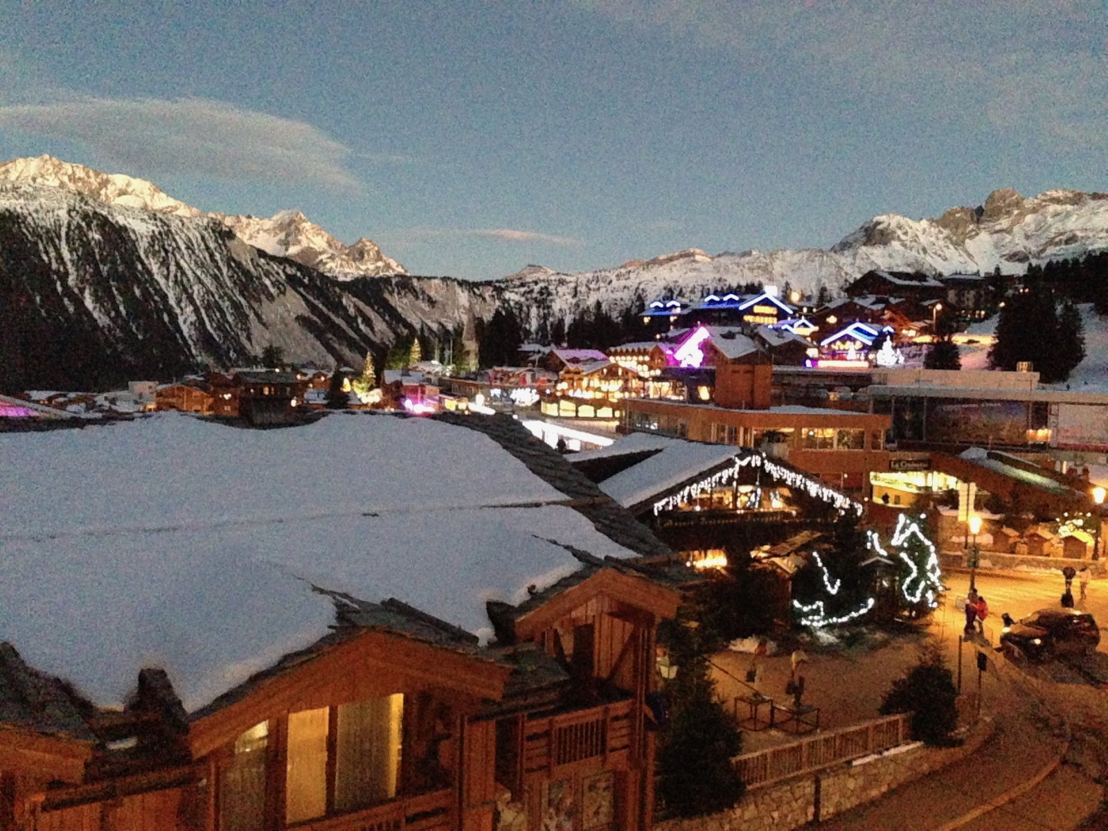Courchevel al anochecer, con los chalets iluminados y las cumbres nevadas al fondo