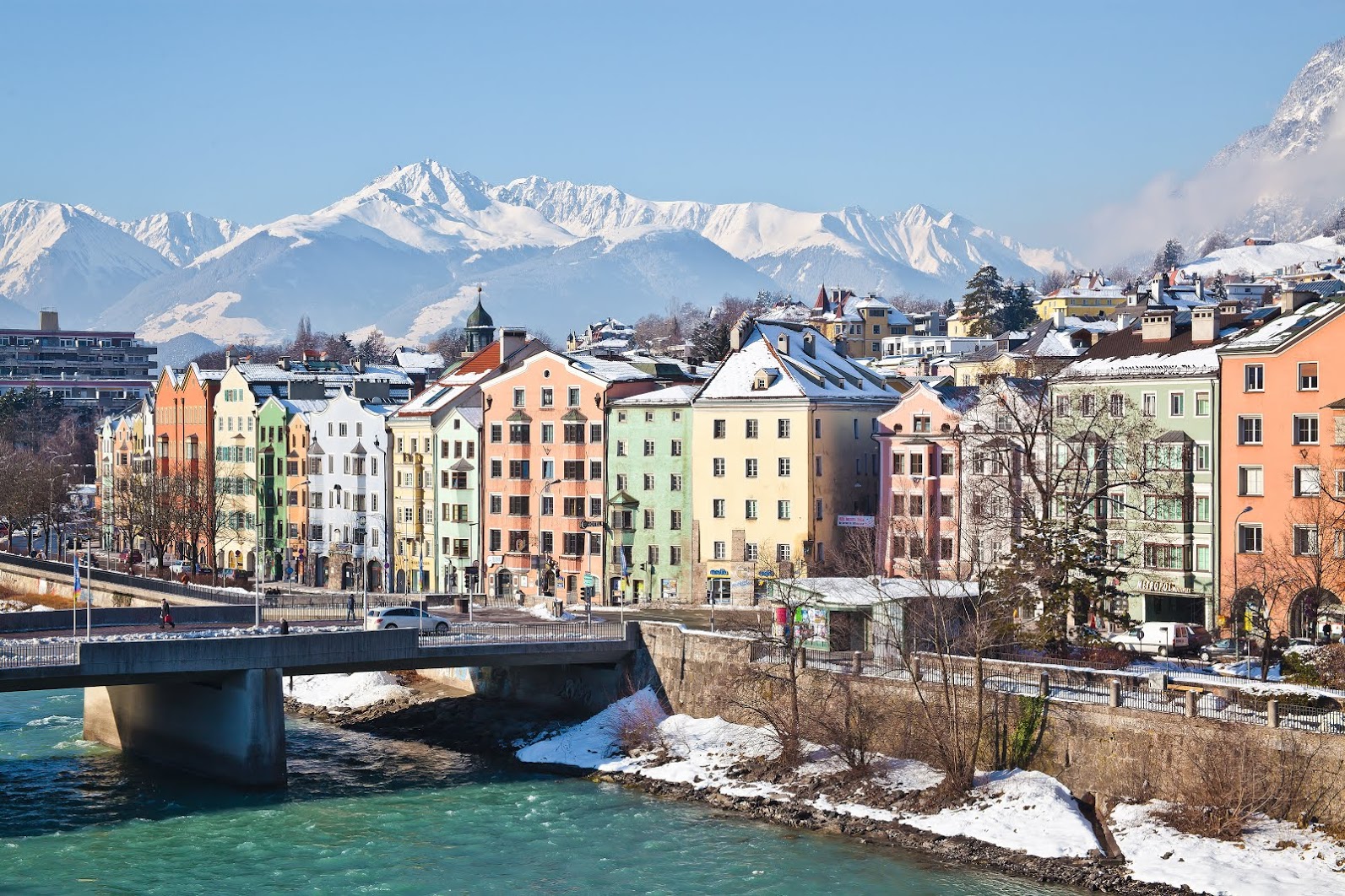 Las casas de colores de Innsbruck junto al río Inn, con las montañas nevadas detrás