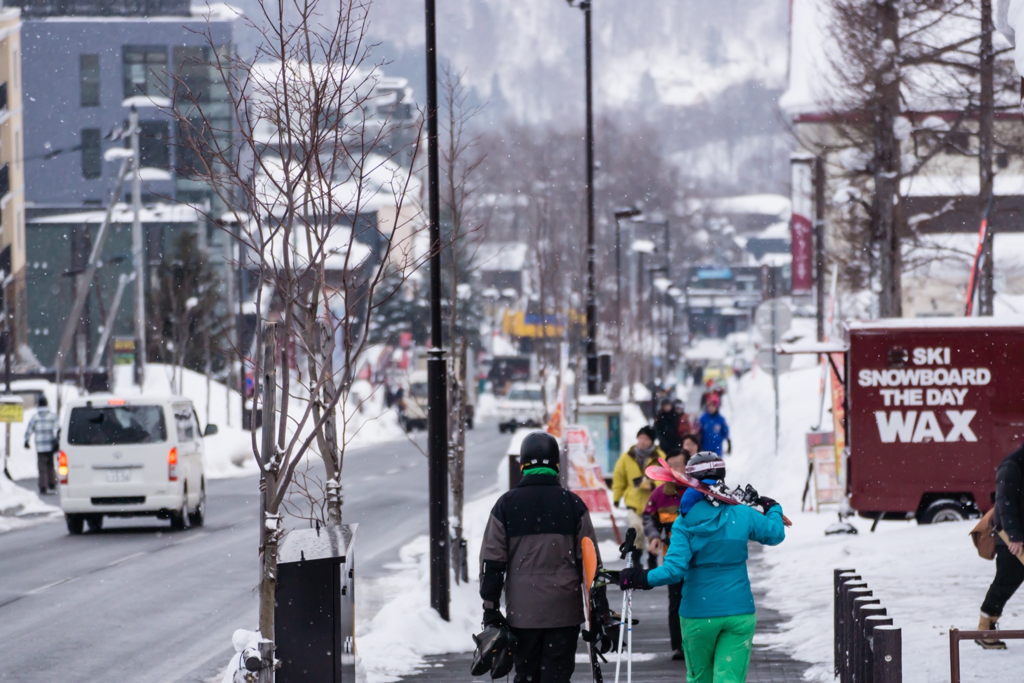 Esquiadores caminando por la calle nevada de un pueblo de esquí japonés