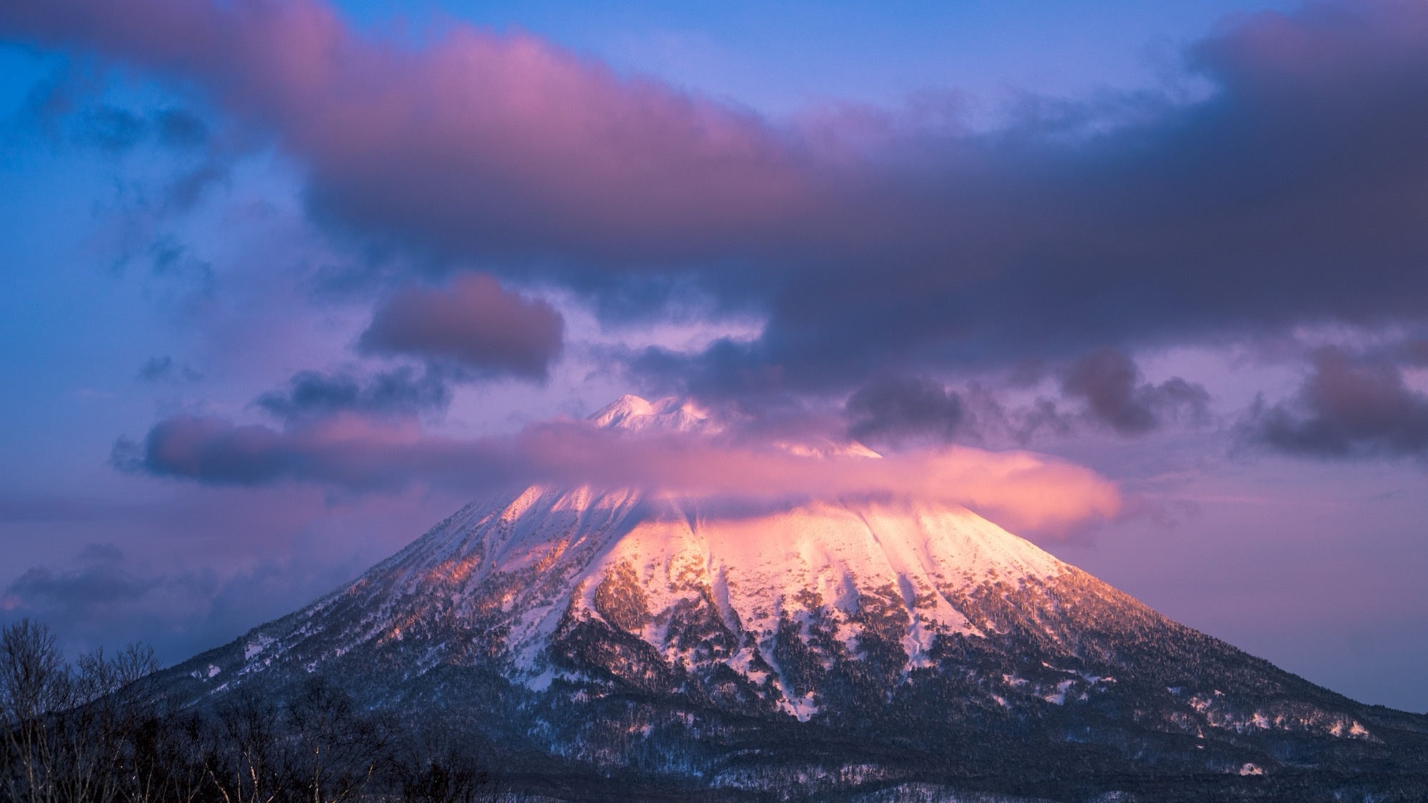 Un volcán nevado de cono perfecto al atardecer, en Hokkaido